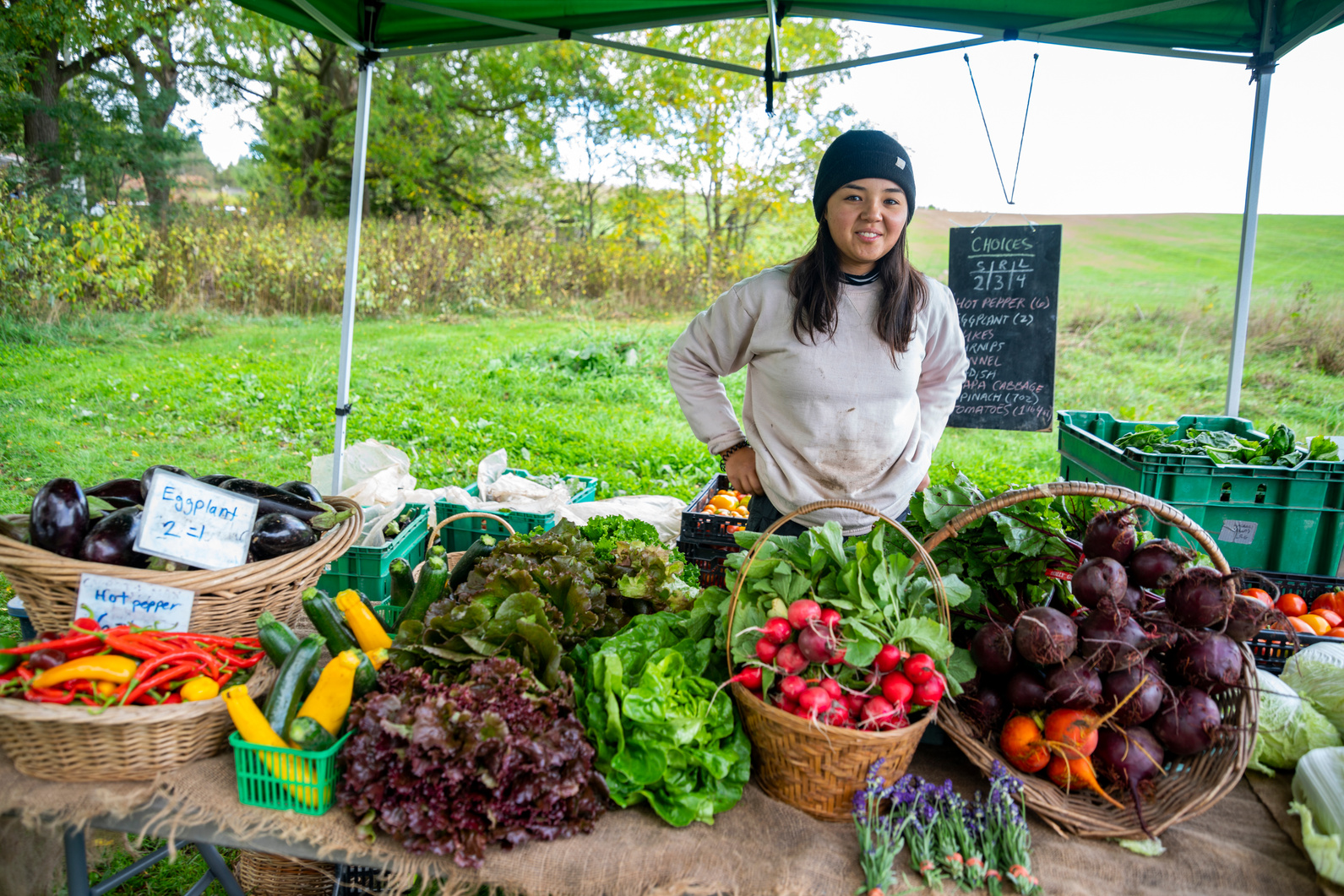 An organic farmer at an outdoor farm stand